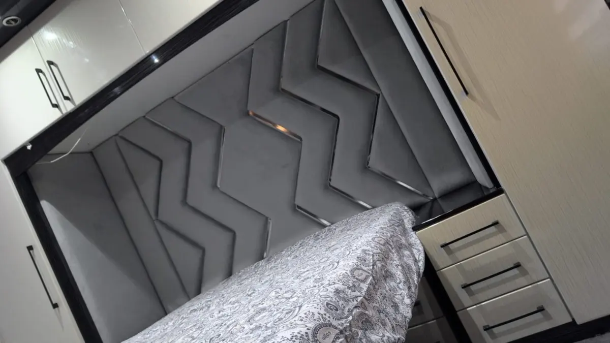 Grey upholstered chevron headboard in a fitted bedroom