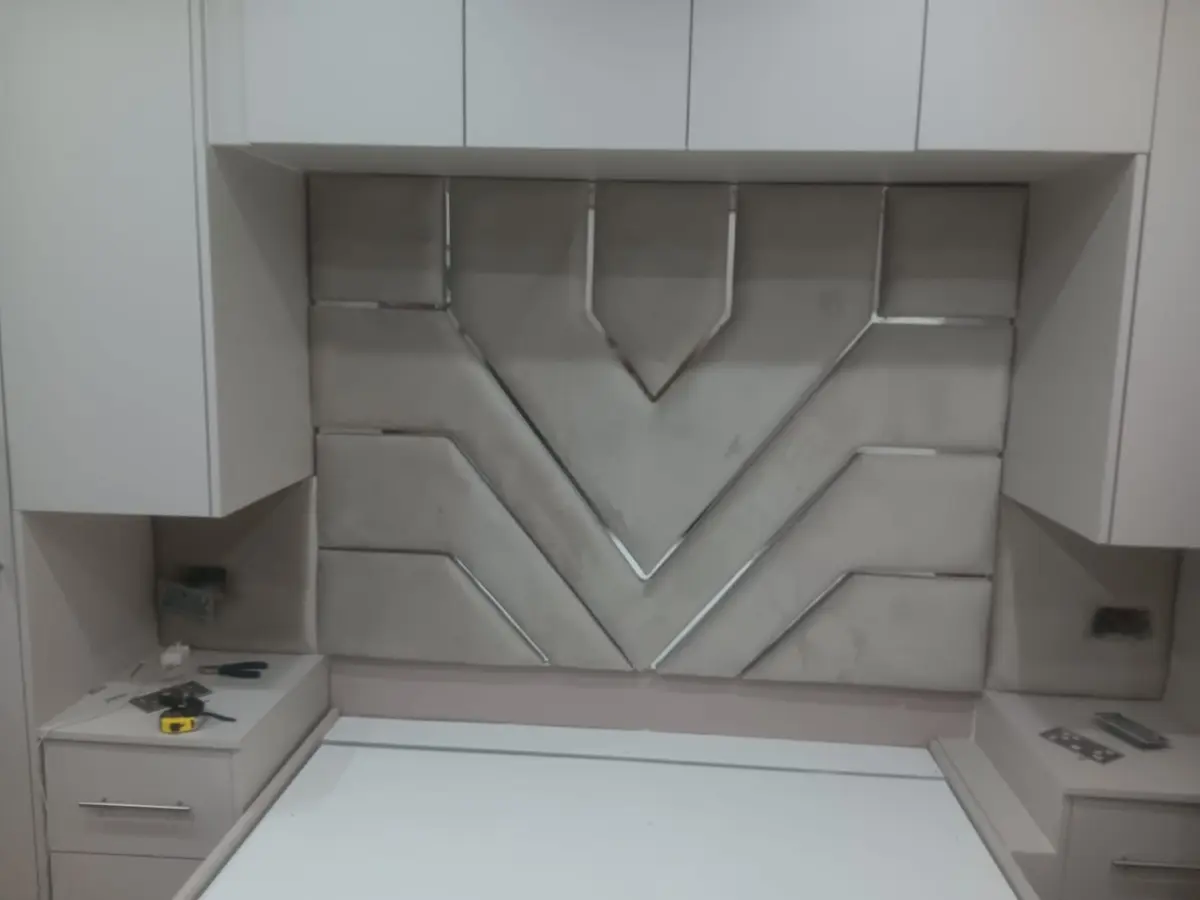 Light grey headboard fitted between bedroom cabinets