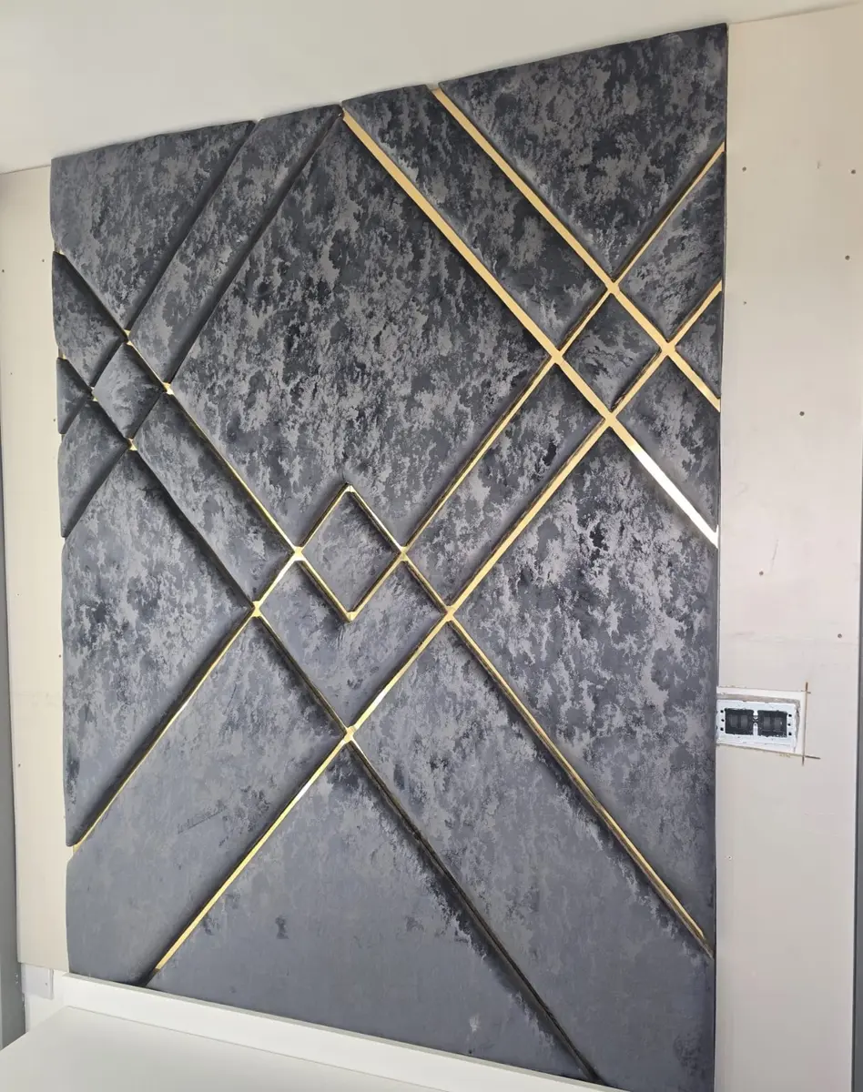 Silver geometric upholstered wall panels with metallic trim