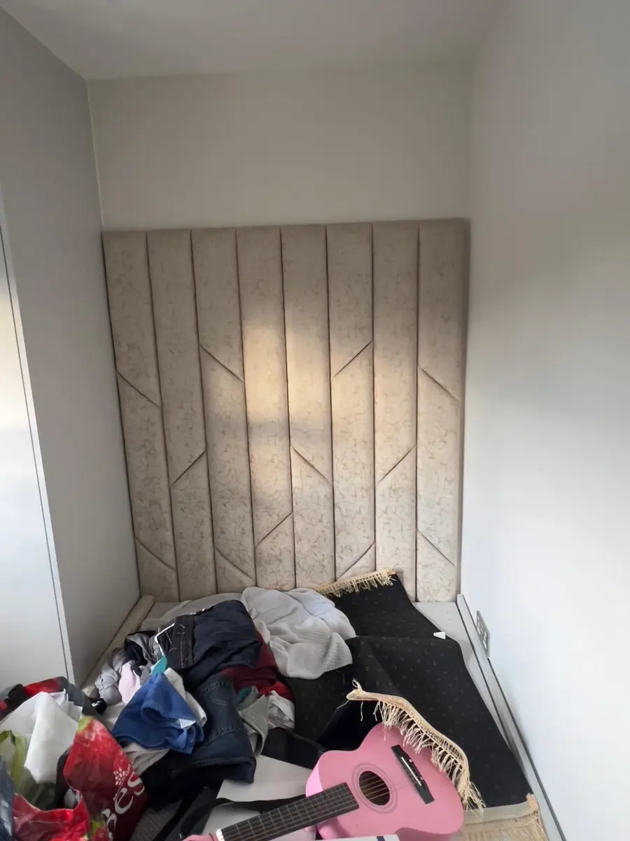 Full-height beige upholstered headboard